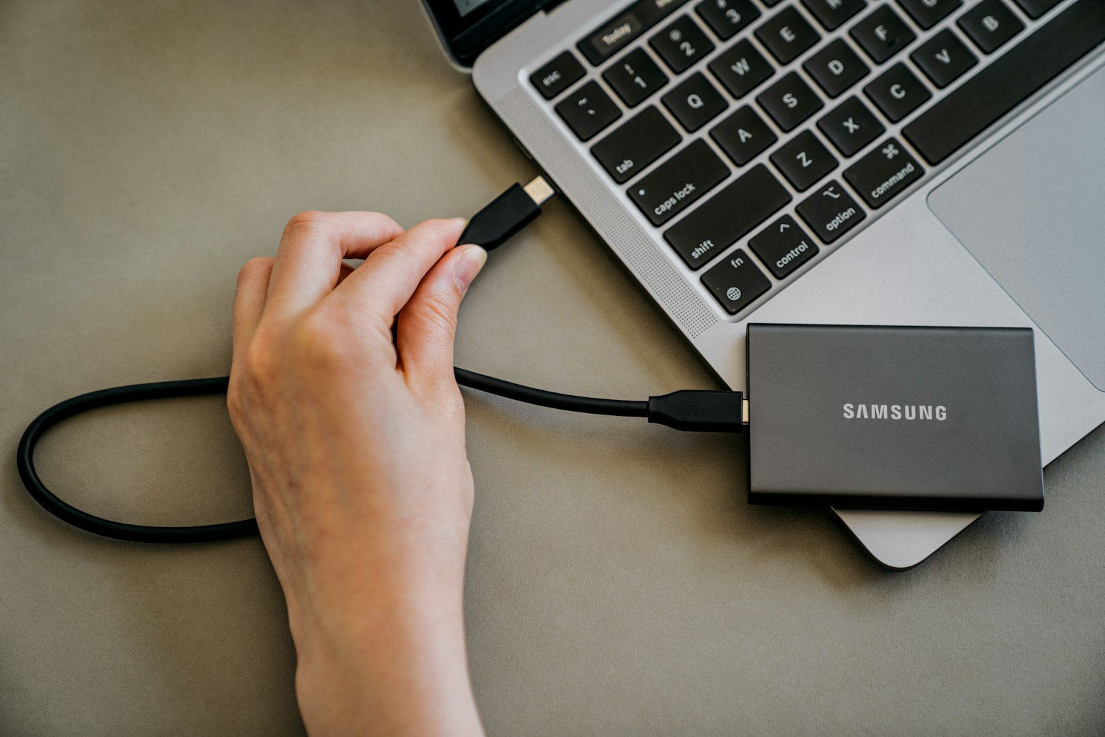 Photo by Samsung Memory A person is plugging a charger into a laptop